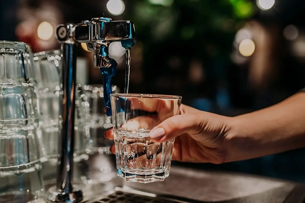 Gewerblicher Getränkebereich mit Zapfhahn und Glas als Beispiel für Wasseraufbereitung im Gewerbe.