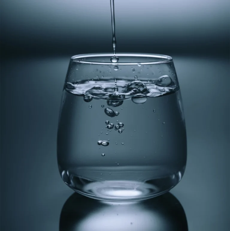 Glas mit Wasser und aufsteigenden Bläschen als Symbol für eine moderne Wasserenthärtungsanlage.