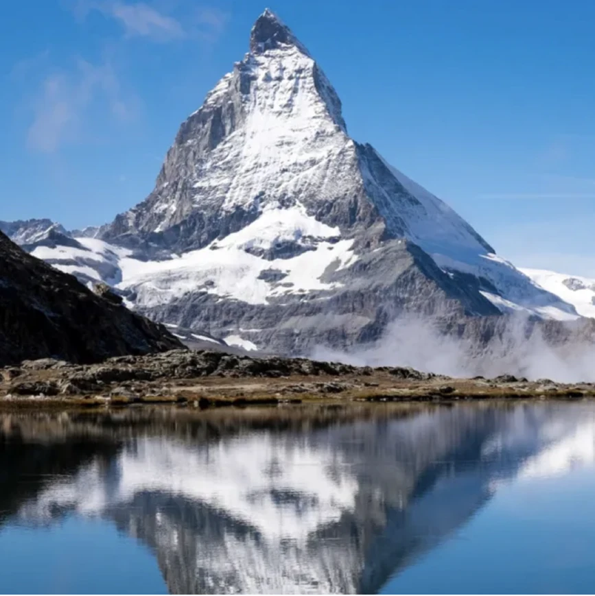 Schneebedeckter Berg mit Spiegelung im See als Bildmotiv zum Thema Wasserenthärtung und Wasserqualität.